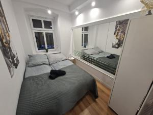 a small bedroom with a bed and a mirror at Apartament Antracyt in Wałbrzych