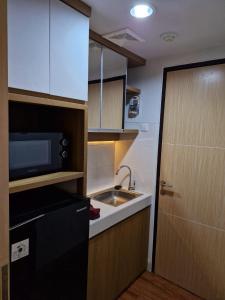 a small kitchen with a sink and a microwave at Alton City Loft in Jatingaleh