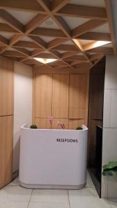 a reception desk in a room with a coffered ceiling at Alton City Loft in Jatingaleh +18 photos