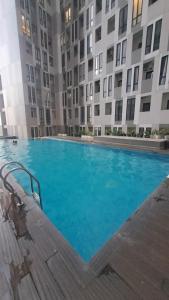 a large blue swimming pool in front of a building at Alton City Loft in Jatingaleh