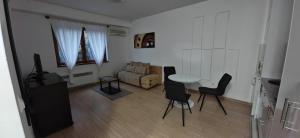 a living room with a table and chairs and a couch at Apartman Besu in Vrnjačka Banja