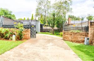 Peaceful luxurious fully-equipped home في سنتوريون: ممر يؤدي إلى منزل مع سور