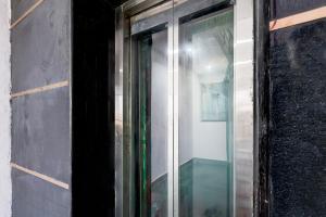 una ventana de vidrio en el costado de un edificio en Hotel O Shalimar, en Ghaziabad