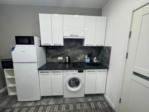 een witte keuken met een wasmachine en een wastafel bij Apartament ultra-central in Edineţ +11 foto's