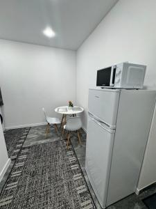 a kitchen with a refrigerator and a table with a microwave at Apartament ultra-central in Edineţ