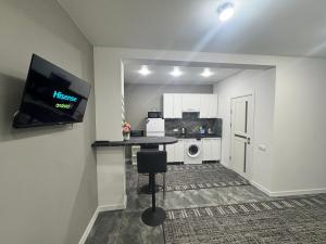 a kitchen with a table and a tv in a room at Apartament ultra-central in Edineţ