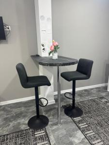 a table with two chairs and a vase of flowers on it at Apartament ultra-central in Edineţ