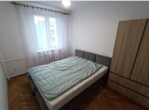 a small bedroom with a bed with a window at Apartament do wynajęcia in Jarosław