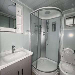 een badkamer met een douche en een wastafel bij Residencial Manhattan in Passo Fundo