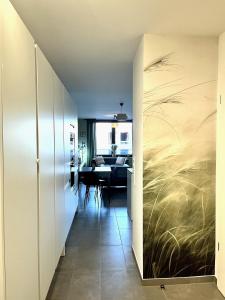 a hallway with a dining room with a painting of grass at La Loggia - Appartement Terrasse Esch Belval in Esch-sur-Alzette