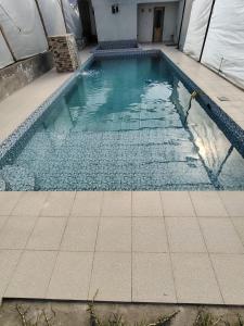 una piscina con suelo de baldosa en Coney Camping, en Ambato