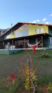 een huis met rode bloemen ervoor bij Sitio e Pousada Vagalumes in Engenheiro Passos