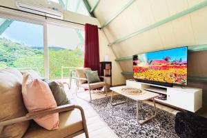 a living room with a large tv and a couch at Cabañita cozy cerca del centro in Alto Boquete