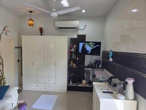 a living room with a white cabinet and a tv at Fehivilla Residence in Dhangethi