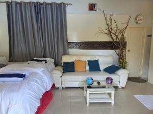 a living room with two beds and a couch at Fehivilla Residence in Dhangethi