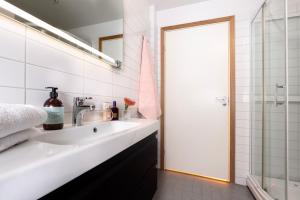 a white bathroom with a sink and a shower at Tromsø Town and Nature in Trondalen +20 photos
