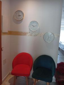 Appartement familial à 100 m de la mer في الحرحورة: ثلاث ساعات على الحائط مع كرسيين