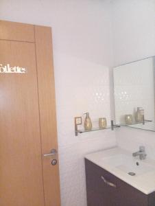 Appartement familial à 100 m de la mer في الحرحورة: حمام مزود بحوض ومِرآة +صورتان