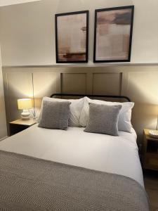 a bedroom with a white bed with two pillows at Kirkview Cottage in Peterhead