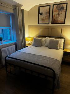 a bedroom with a large bed with two pillows at Kirkview Cottage in Peterhead