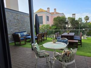 a patio with a table and chairs on a deck at Casa dos sonhos em Vale do Lobo in Loulé