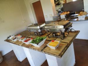 a buffet line with different types of food on a counter at African Dream Tents in Graskop