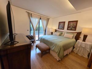 a bedroom with a bed and a television in it at Casa dos sonhos em Vale do Lobo in Loulé
