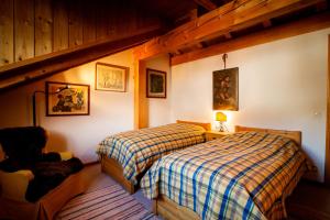 Un dormitorio con dos camas y una silla. en Chesa Principela - La Punt, en La Punt-Chamues-ch