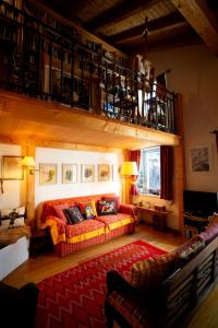 Una sala de estar con un sofá y un balcón. en Chesa Principela - La Punt, en La Punt-Chamues-ch