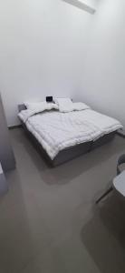 Saran Homestay في آغْرا: سرير في غرفة بيضاء مع مرتبة بيضاء