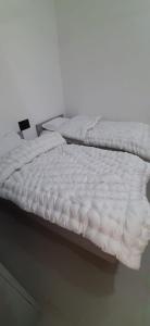 Saran Homestay في آغْرا: سرير عليه شراشف بيضاء في الغرفة +8 صور