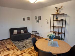 a living room with a table and a couch at Guesthouse Les Tilleuls in Fleurus +32 photos