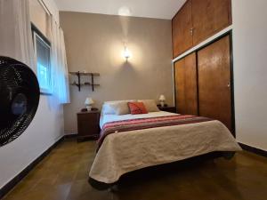 a bedroom with a bed with a dresser and a fan at Oasis in Villa Anizacate +19 photos