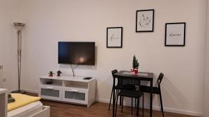 a room with a table and a tv on a wall at Apartment Sanja in Belgrade +1 photo