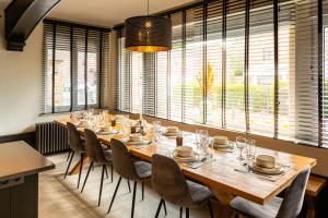 a dining room with a large wooden table and chairs at Villa Basse Cour in Durbuy