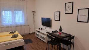 a living room with a desk and a television at Apartment Sanja in Belgrade