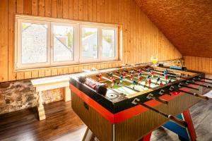 a foosball table in a room with a fireplace at Villa Basse Cour in Durbuy