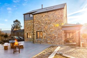 a brick house with a fireplace in a yard at Villa Basse Cour in Durbuy