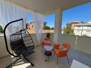 ein Wohnzimmer mit zwei Stühlen und einem Balkon in der Unterkunft Fano Centro Mare in Fano