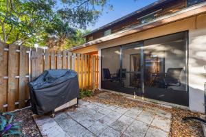 a house with large glass windows and a fence at Beach Townhome Steps from Downtown Cocoa Beach in Cocoa Beach