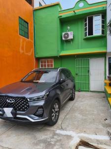 a car parked in front of a green building at Casa confortable cerca de FORUM in Coatzacoalcos