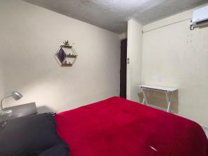 a bedroom with a red bed with a red blanket at Casa confortable cerca de FORUM in Coatzacoalcos