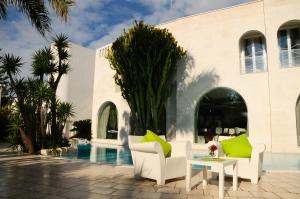 eine Terrasse mit Stühlen und einem Tisch neben einem Pool in der Unterkunft Il Grillo Hotel in Pulsano