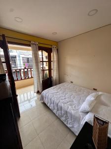 Un dormitorio con una cama y una ventana grande. en Habitación privada con terraza, en Quimbaya