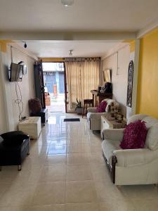 Una gran sala de estar con sofás y un televisor. en Habitación privada con terraza, en Quimbaya