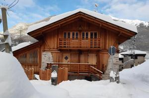 a wooden cabin with snow on the roof at Exclusive Chalet Maso Molini in Terzolas