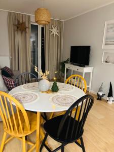 a dining room table and chairs with a christmas tree on it at apartament Gaja in Świnoujście