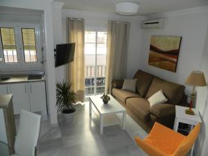 salon z kanapą i stołem w obiekcie Apartamento Miramar w Maladze