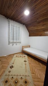 a room with a bed and a rug on the floor at Vikendica Miki 2 in Bratunac