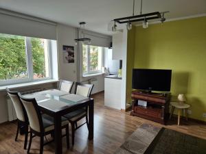 een eetkamer met een tafel en een televisie bij Kesklinna silla apartment - free parking in Pärnu